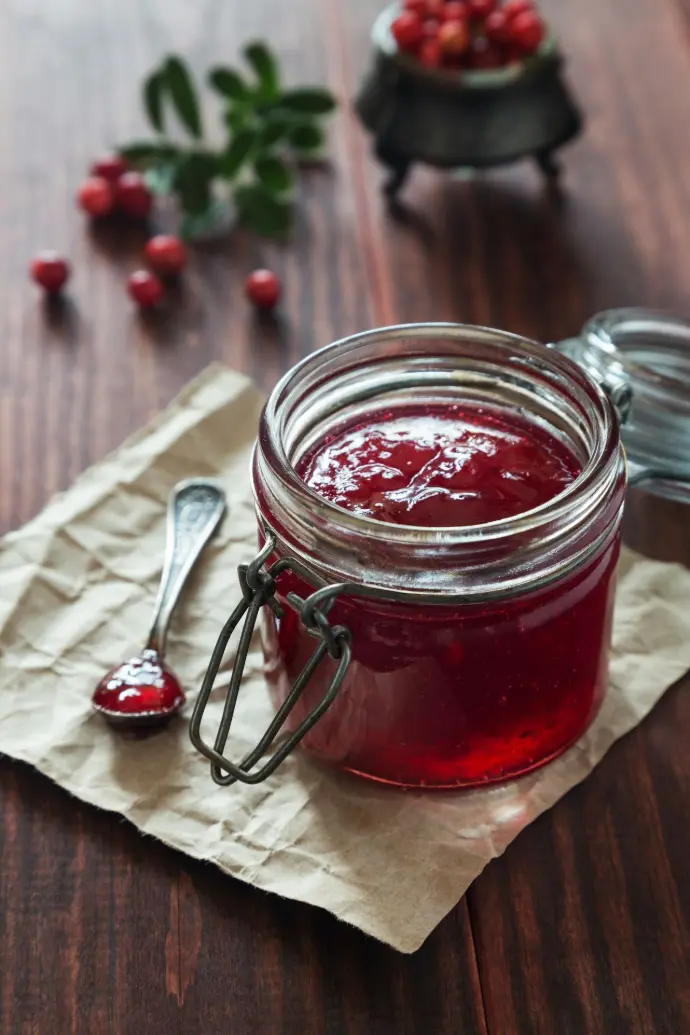 Cranberry jam in a jar with cranberries.